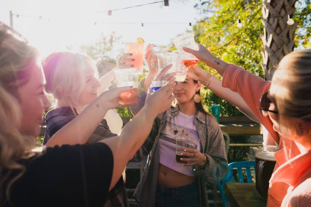 A group of friends clinking their drinks together.